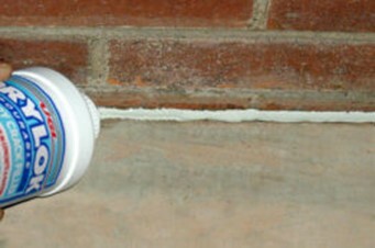 Patching floor and wall joint with DRYLOK Pourable Crack Filler